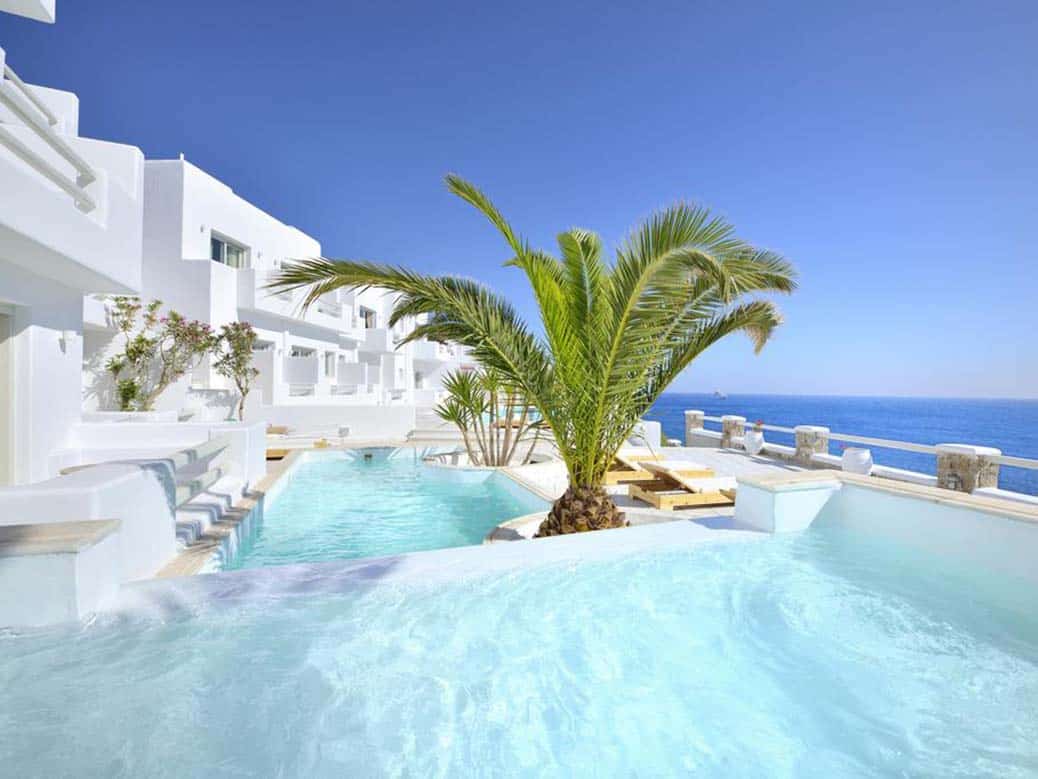 Beautiful morning hotel photo of swimming pool and building of Nissaki Hotel Mykonos Greece